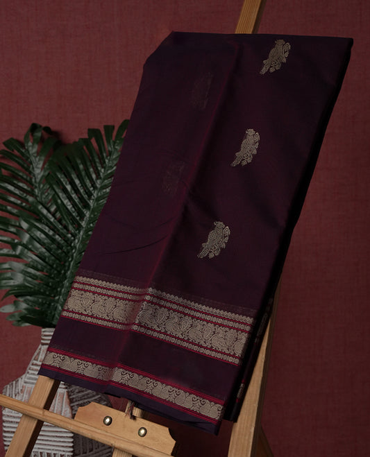 Deep maroon colour pure Kanchi cotton saree adorned with subtle beige zari motifs across the body,  The intricate zari woven border adds a touch of tradition & Includes a matching blouse piece for a complete look.