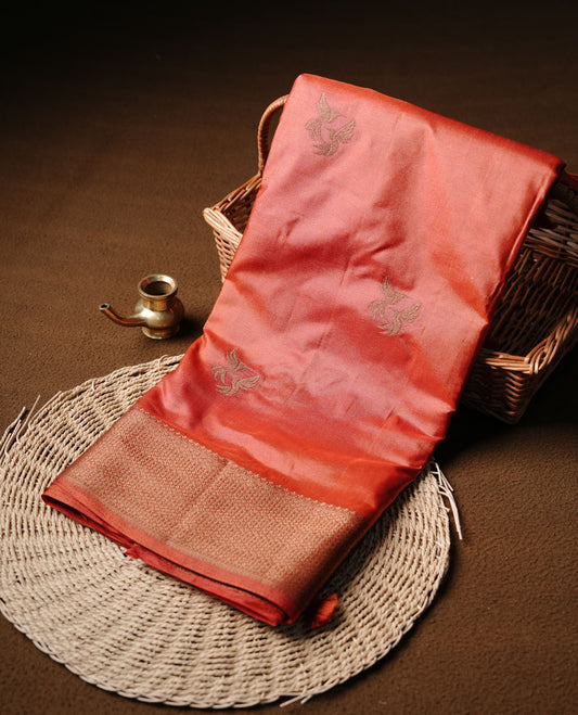 Brick red colour semi banaras tussar silk saree highlighting gold zari bird motifs on body, complemented by self colour with antique zari border, paired with matching blouse piece.