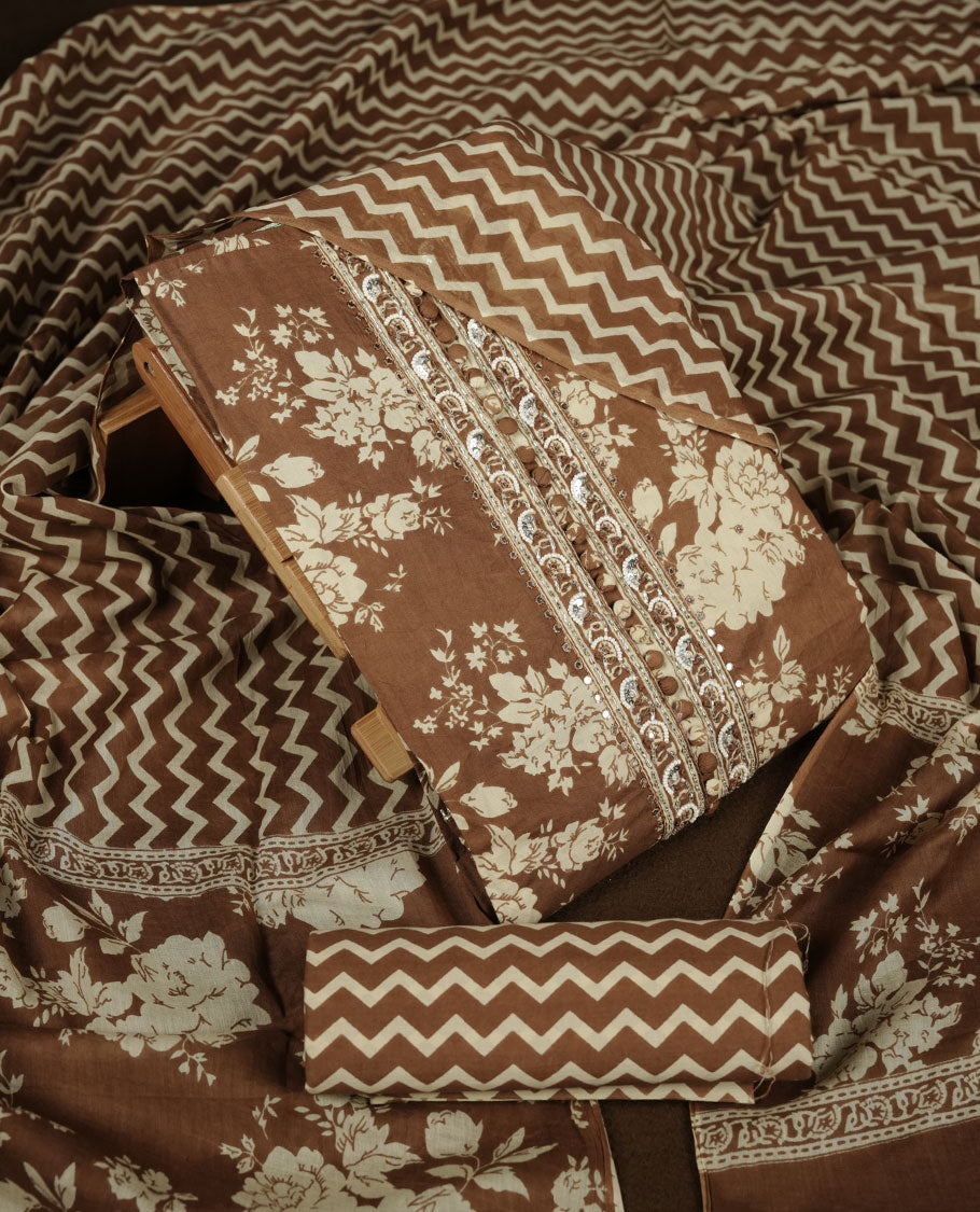 Brown colour churidar set with cream colour floral print, stone and thread embroidery and detailing, paired with matching pant and dupatta.