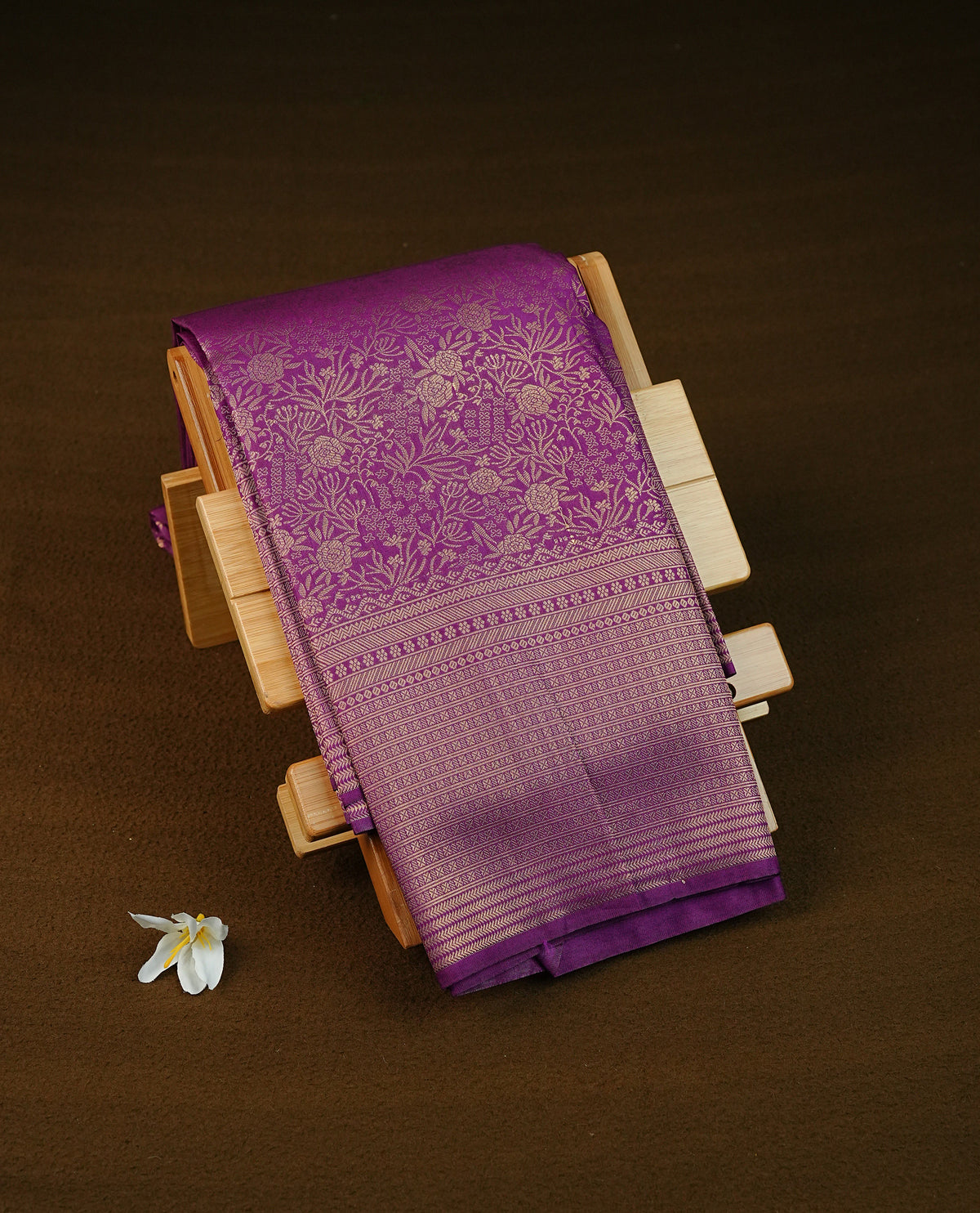Purple colour semi silk saree featuring floral gold zari patterns on body, contrast self colour with traditional border on body, grand pallu comes with matching blouse piece
