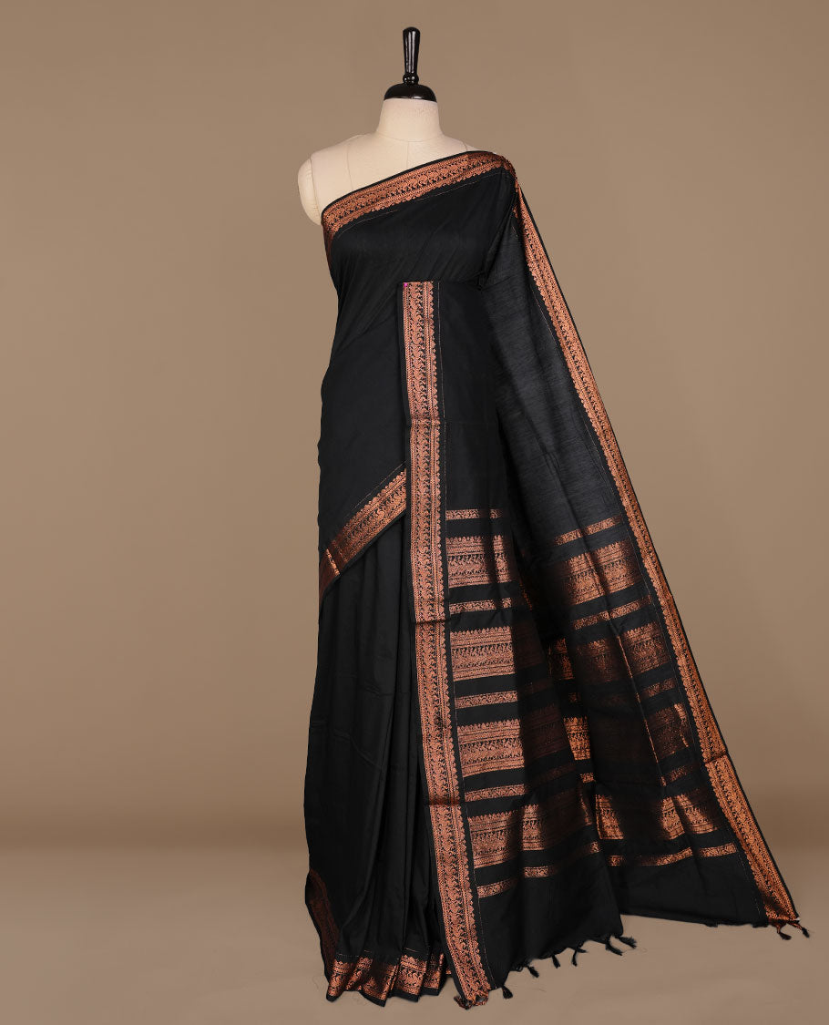 Black colour kalyani cotton saree featuring Elegant plain body, complemented by selfcolour with Antique zari border, paired with matching blouse piece.