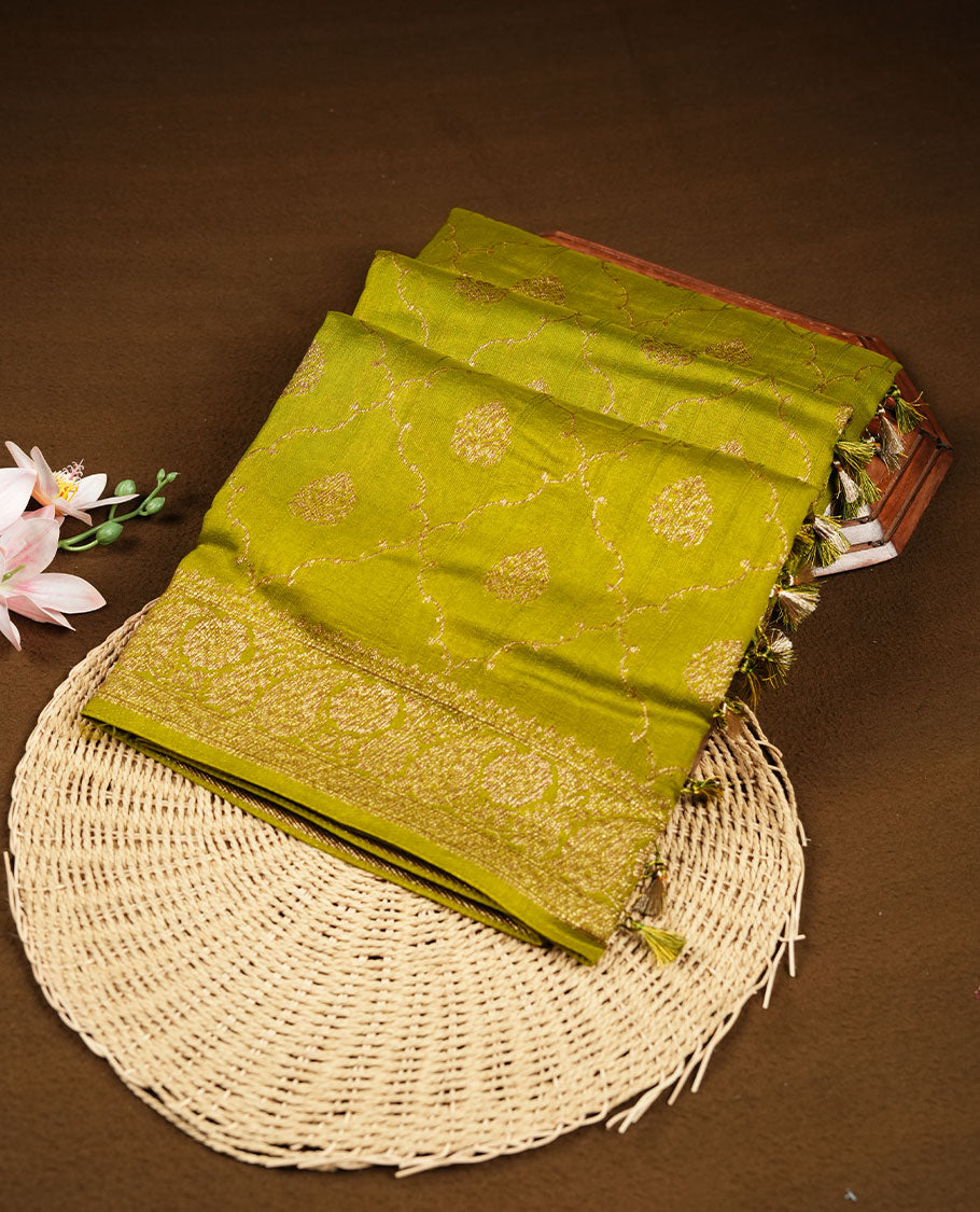 Olive colour semi Banaras saree with gold zari buta motifs, finished with a traditional gold zari border and pallu, paired with a matching blouse.