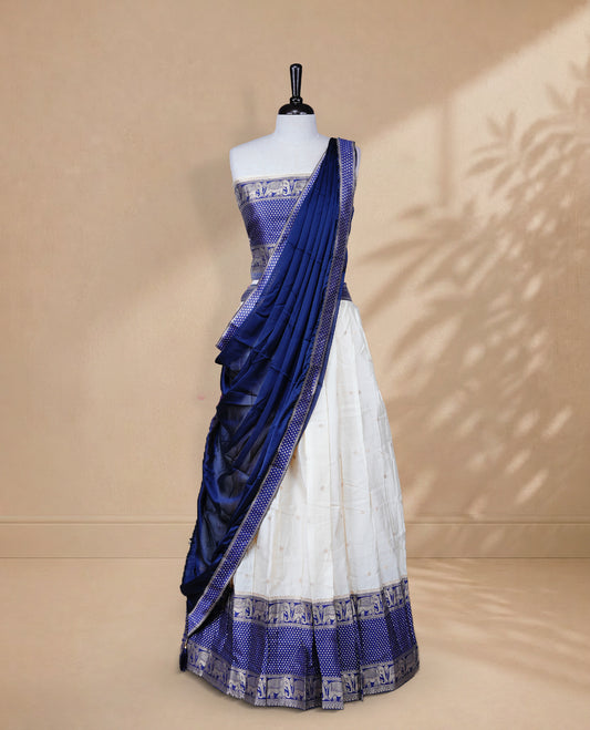 Cream colour Half saree featuring Gold zari buttas on skirt with Zari border on contrast Blue colour border, Unstitched Blouse and matching dupatta.