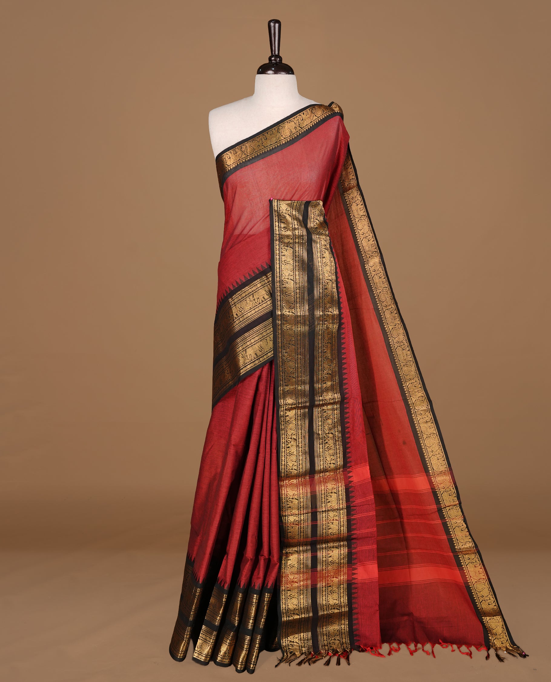 Red colour Chettinad cotton saree featuirng Elegant Plain body, complemented by contrast black colour with gold zari border, paired with matching blouse piece.