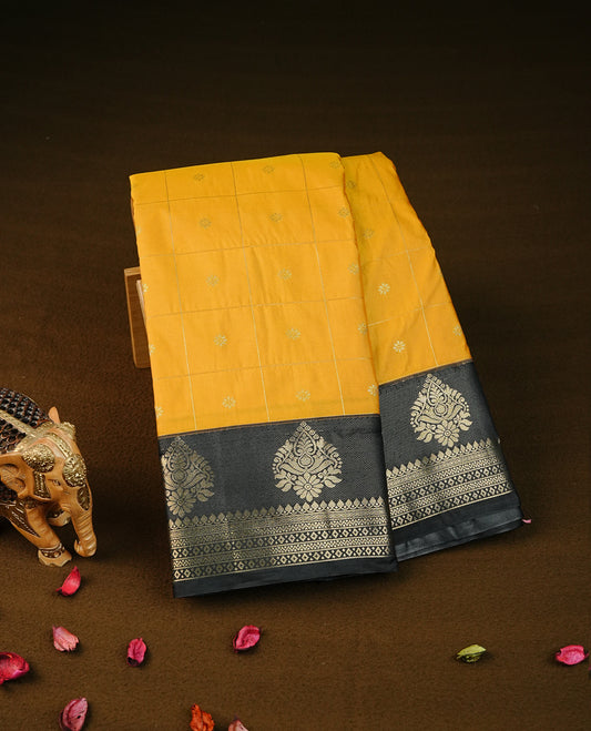 Yellow colour semi wedding silk saree featuring gold zari checks with buttas on body,contrast black colour with traditional border on body,rich pallu comes with matching blouse piece