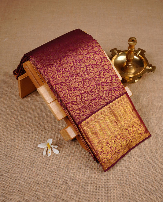 Burgundy colour kancheepuram silk saree featuring gold zari pattern across body, complemented by selfcolour border traditional zari border, paired with matching blouse piece.