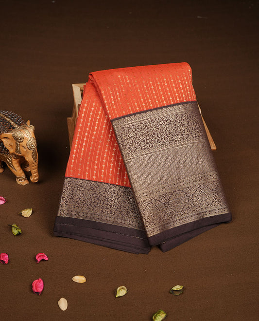Rust orange colour semi silk saree featuring gold zari dotted stripes and stripes on body highlighting contrast dark chocolate gold zari  floral kodi border , paired with matching blouse