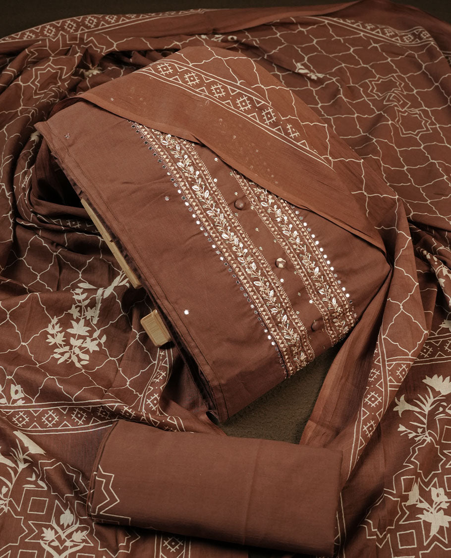 Chocolate brown colour churidar material featuring delicate thread embroidery with subtle mirror accents on the front panel, paired with a printed dupatta and matching bottom.