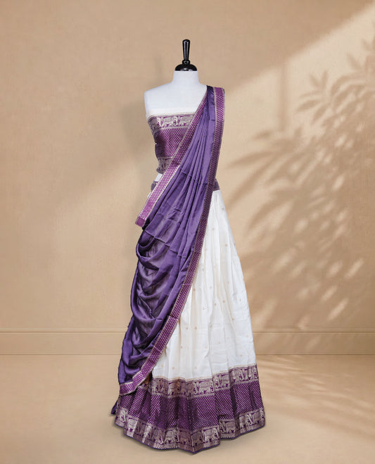 Cream colour Half saree featuring Gold zari buttas on skirt with Zari border on contrast Purple colour border, Unstitched Blouse and matching dupatta.