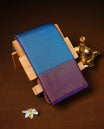 Teal Colour Semi wedding silk saree Featuring Silver Zari Check across Body, Complemented by Contrast Purple Colour With traditional Border, paired with matching blouse Piece.