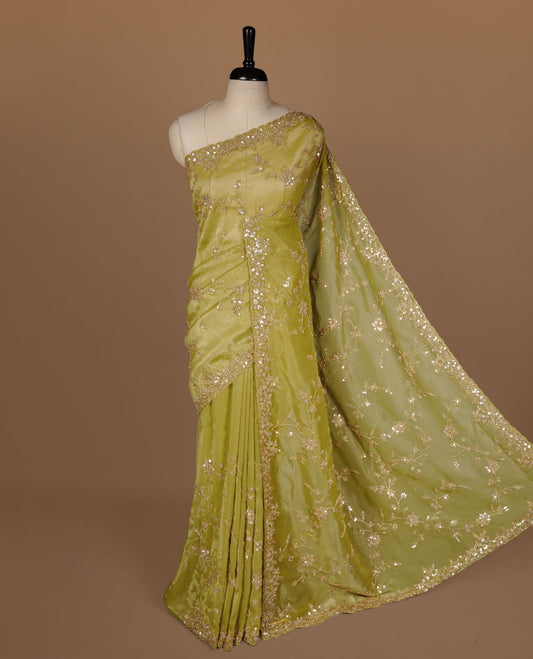 Olive colour net organza saree featuring cut beats and sequins floral kodi pattern on body, enhanced with worked border and cut beats work on blouse piece.
