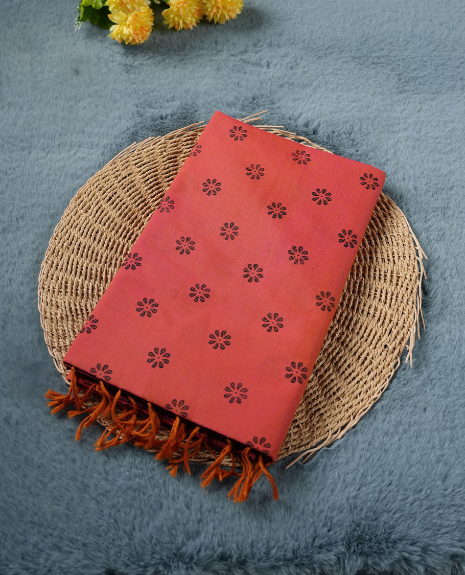 Peach Orange colour poly cotton saree with black floral butti motifs on the body, paired with a matching pallu featuring black ornate floral jaal and stripes on the border, and a coordinated all‑over black paisley printed blouse piece.