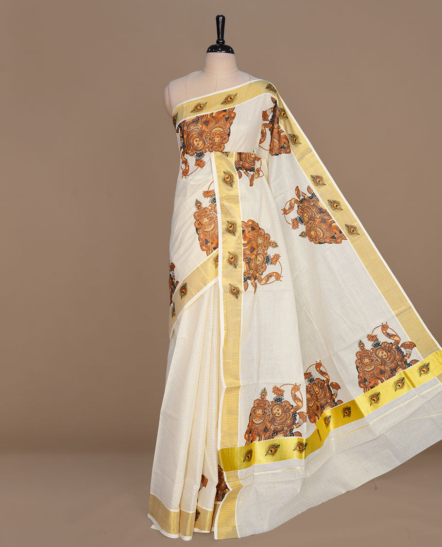 Off white color kerala cotton saree featuring gold zari check on body, complemented by, gold zari with krishna & peacock leaf printed border, paired with matching blouse piece.