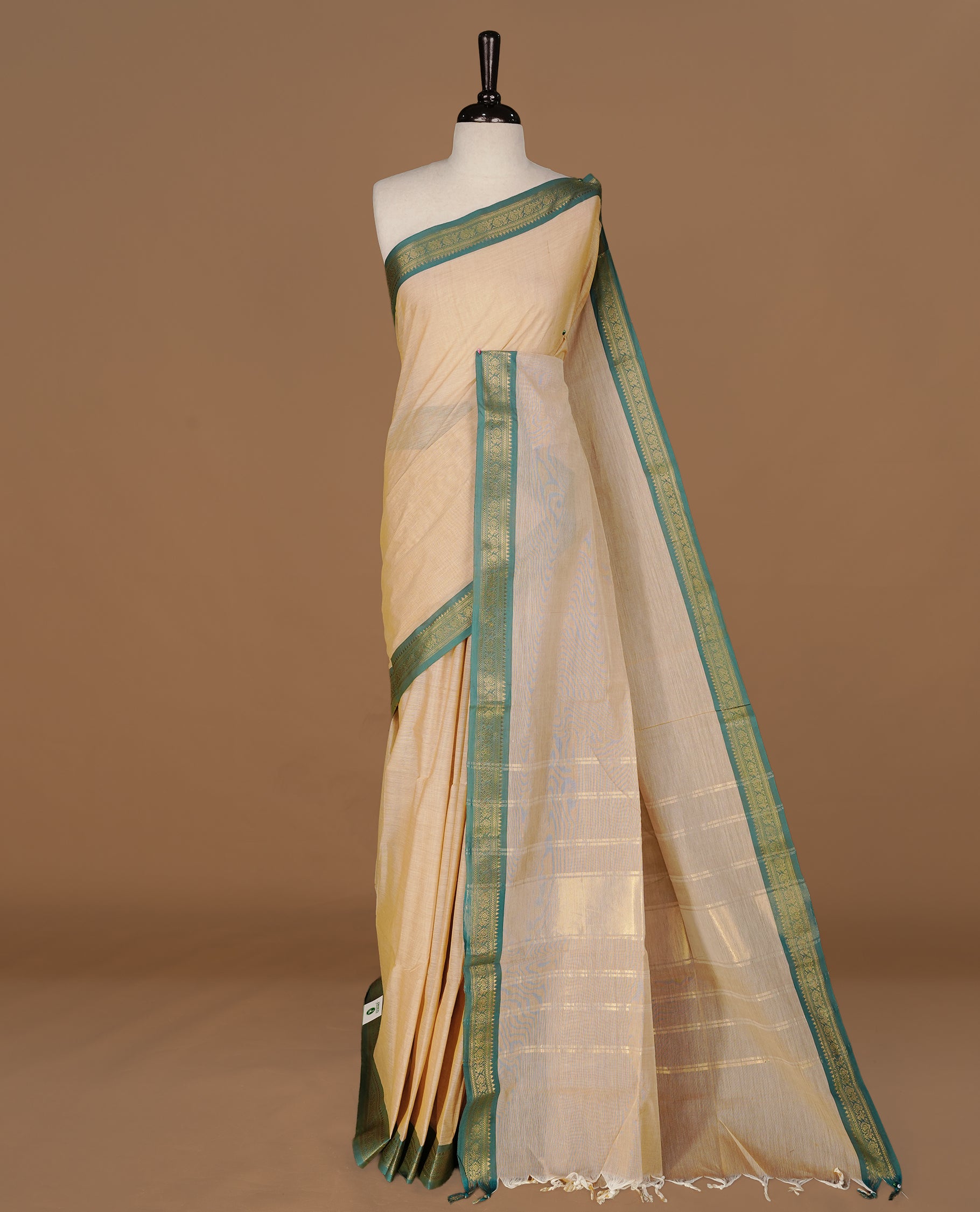 Peachy cream Colour Chettinad cotton saree featuring elegant plain body , complemented by contrast Green colour with simple traditional border, comes with matching blouse piece.
