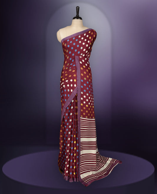 Maroon colour saree with with large big polka dots on the body, self stripped pallu & Comes with a stylish matching blouse.