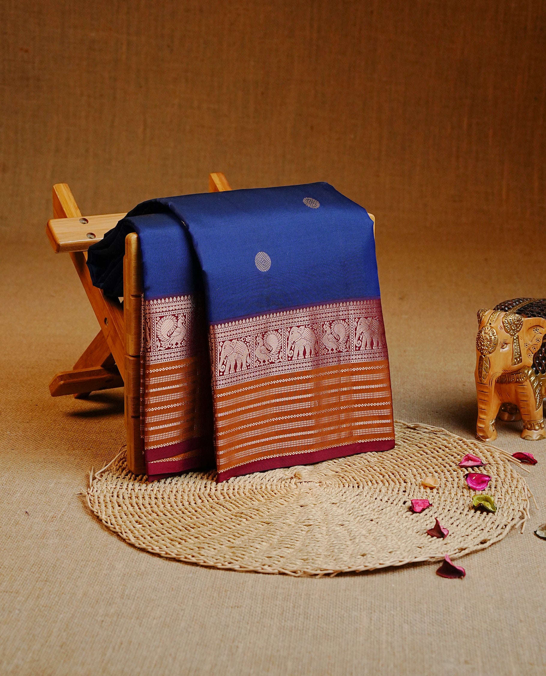 Navy Blue Colour Kancheepuram silk saree featuring gold zari circle motifs on body, highlighting Gold zari Elephant & Peacock Traditional On contrast Maroon & mustard border, paired with Matching blouse piece.