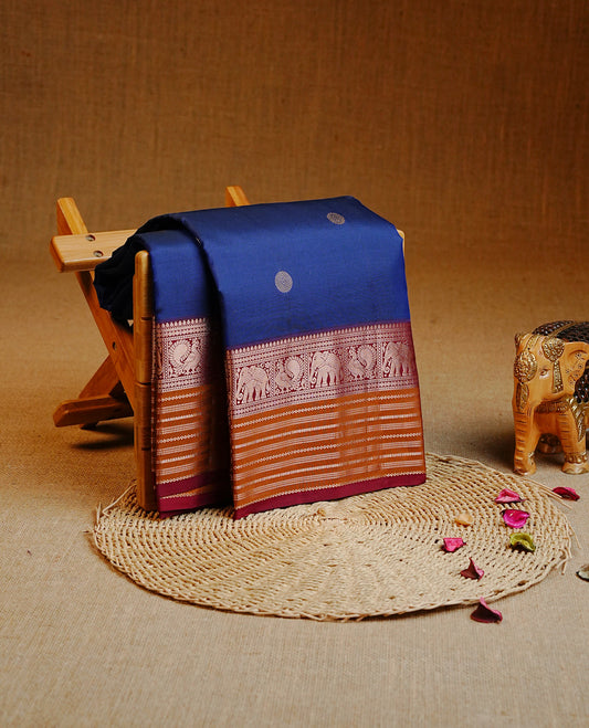 Navy Blue Colour Kancheepuram silk saree featuring gold zari circle motifs on body, highlighting Gold zari Elephant & Peacock Traditional On contrast Maroon & mustard border, paired with Matching blouse piece.