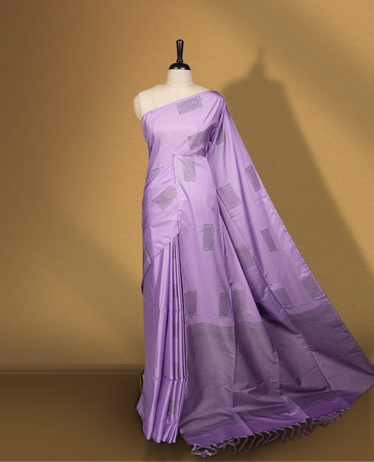 Lavender semi soft silk saree featuring woven rectangular motifs on the body, elegant woven border, and rich matching pallu with tassel finish & Comes with a coordinating blouse piece for a graceful look.