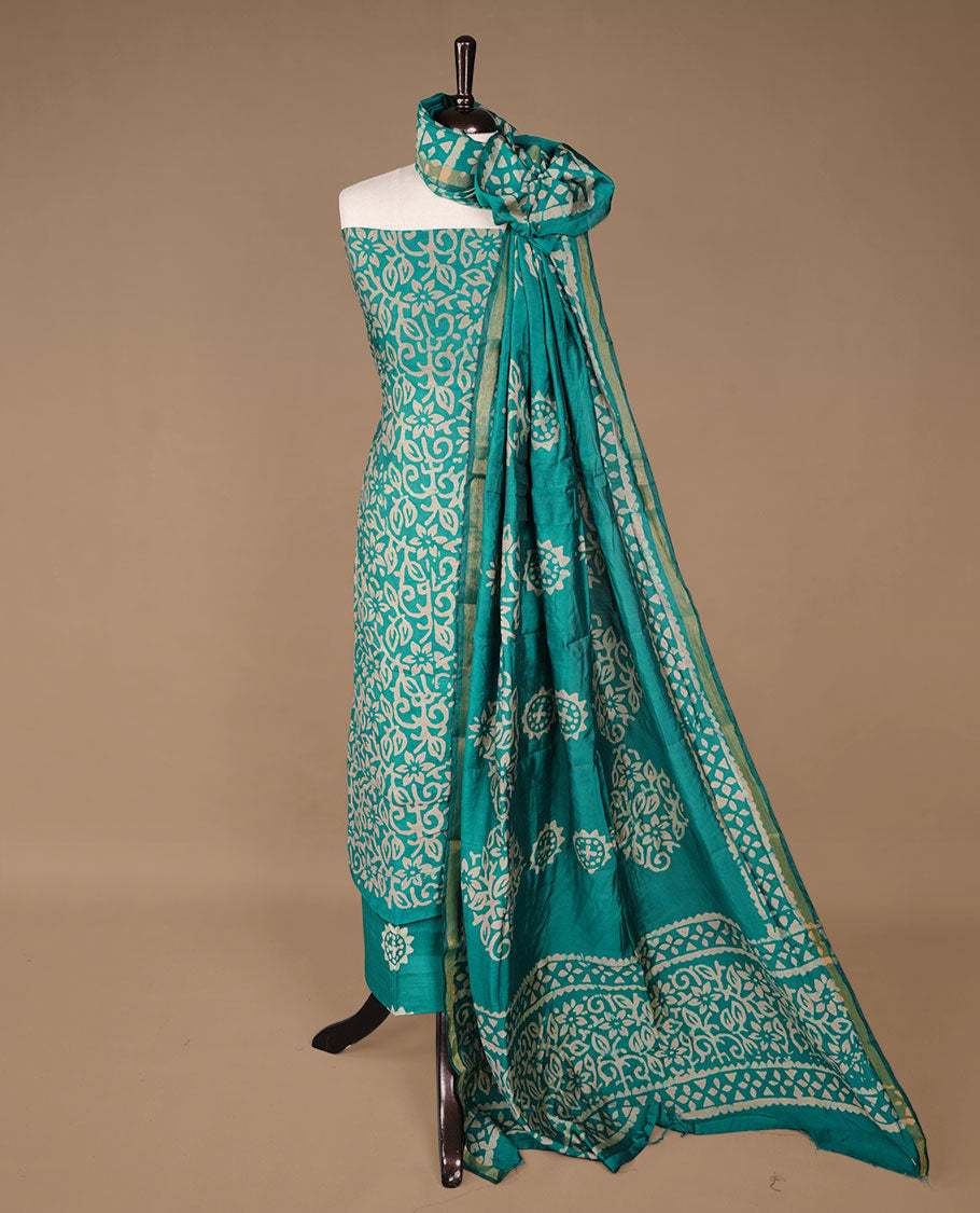 Green colour churidhar material featuring cream colour floral kodi print on body, paired with matching bottom and Dupatta.