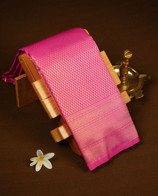 Rani pink colour semi soft silk brocade saree featuring delicate gold brocade patterns on the body, highlighted with a self-colour woven border and pallu, paired with a matching blouse piece.