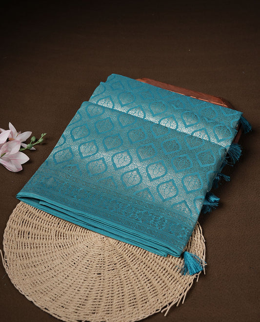 Aqua Blue colour banaras satin crepe saree featuring gold zari pattern across body, with self colour border with gold zari pattern and paired with matching blouse.