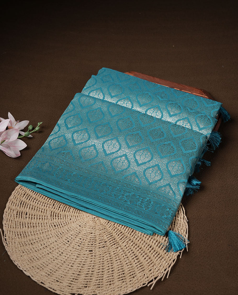 Aqua Blue colour banaras satin crepe saree featuring gold zari pattern across body, with self colour border with gold zari pattern and paired with matching blouse.