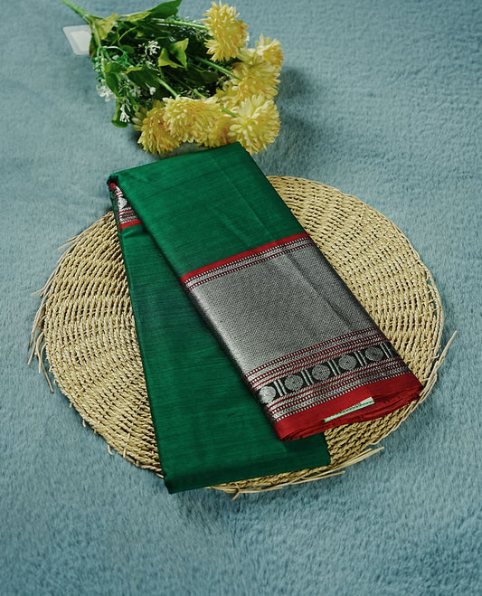 Dark green colour Narayanapattu cotton saree featuring a self coloured body, contrast Dark red colour with silver zari border and pallu, pairing a matching blouse piece.