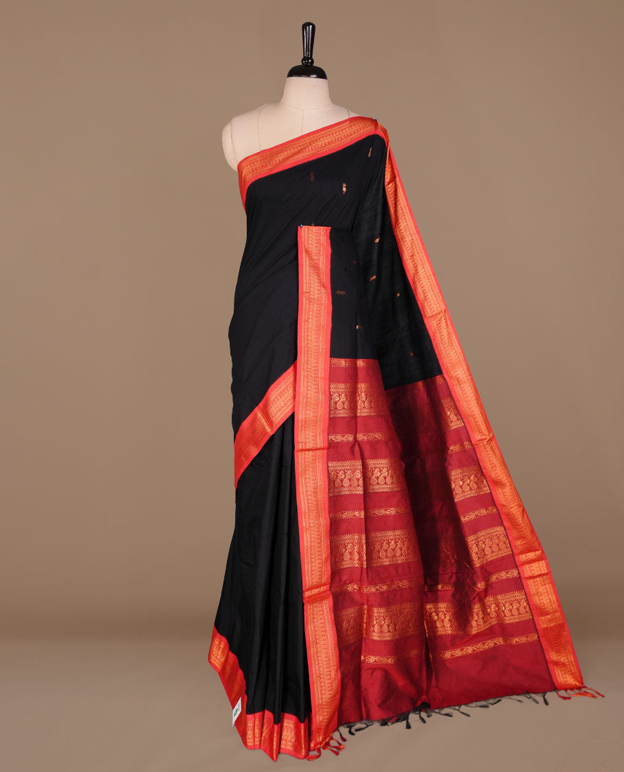 Black colour kalyani cotton saree featuring antique zari motifs on body, complemented by red colour with Antique zari border, paired with matching blouse piece.