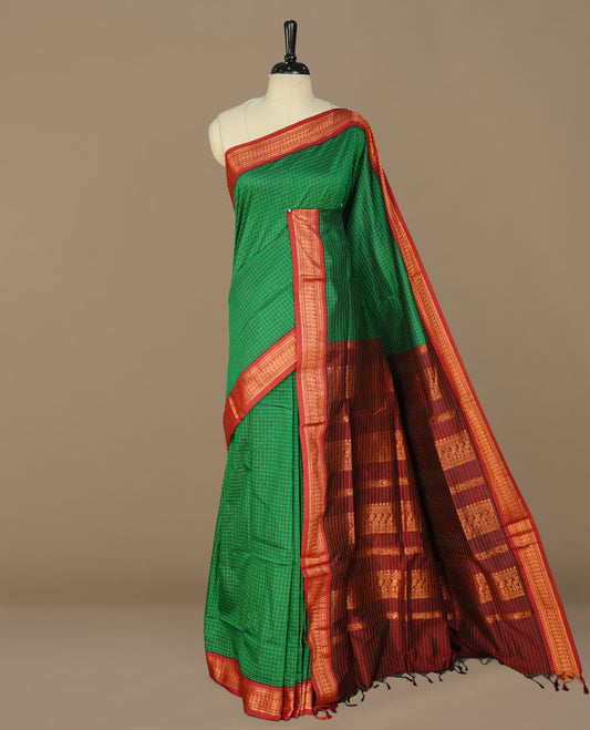 Green colour kalyani cotton saree featuring gold zari check pattern on body, complemented by Maroon colour with Antique zari border, paired with matching blouse piece.