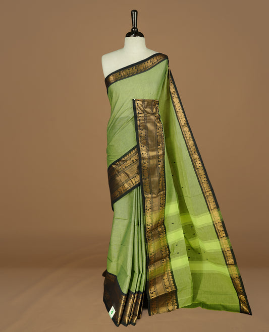 Green colour Chettinad cotton saree featuring motif on body, complemented by Black colour with traditional border, paired with matching blouse Piece.