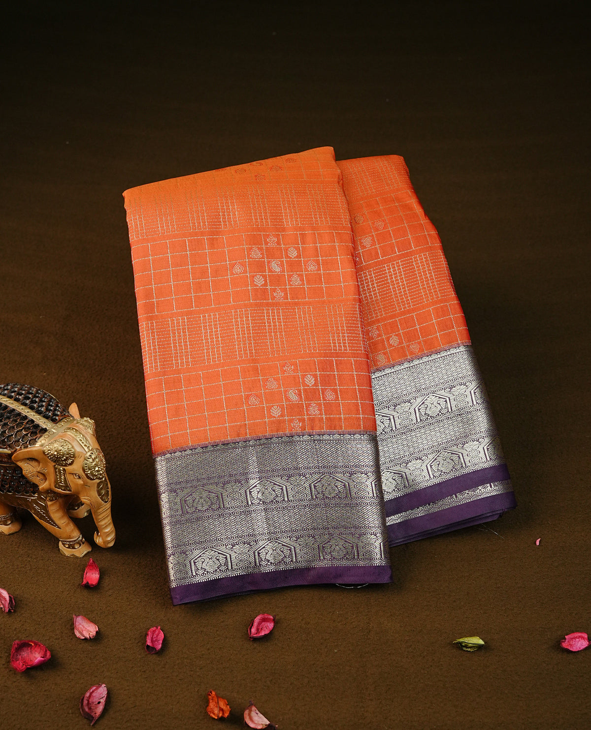 orange colour semi wedding silk saree featuring light gold zari checks with buttas on body, contrast purple colour with traditional border on body, rich pallu comes with matching blouse piece