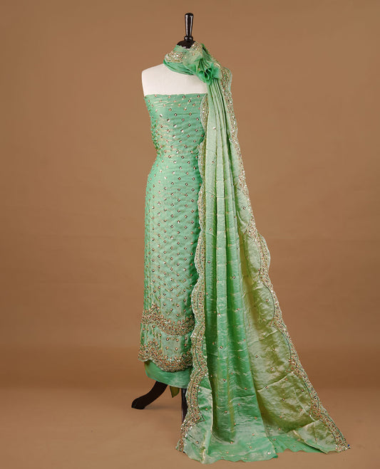 Mint green colour churidhar material featuring cut beads and sequins work on the body, paired with a matching unstitched bottom and worked dupatta.