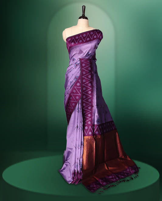 Lavender colour saree featuring subtle woven motifs on the body, enhanced with a deep Purple geometric patterned border, complemented by a rich zari pallu with tassels, and paired with a matching blouse