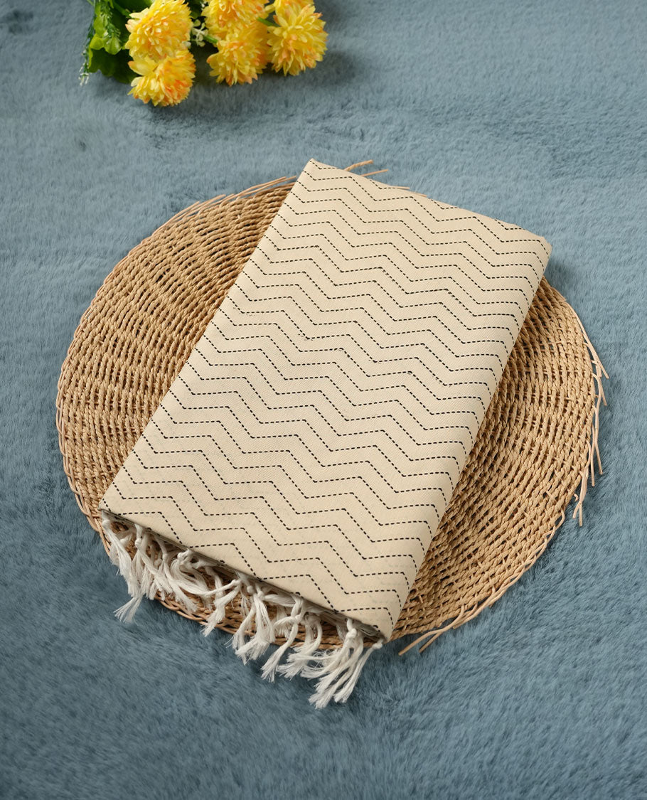 Cream colour poly cotton saree with black zigzag line pattern on the body, paired with a matching pallu featuring black chevron lines and panelled floral‑paisley design, and a coordinated all‑over floral paisley patch‑style printed blouse piece.