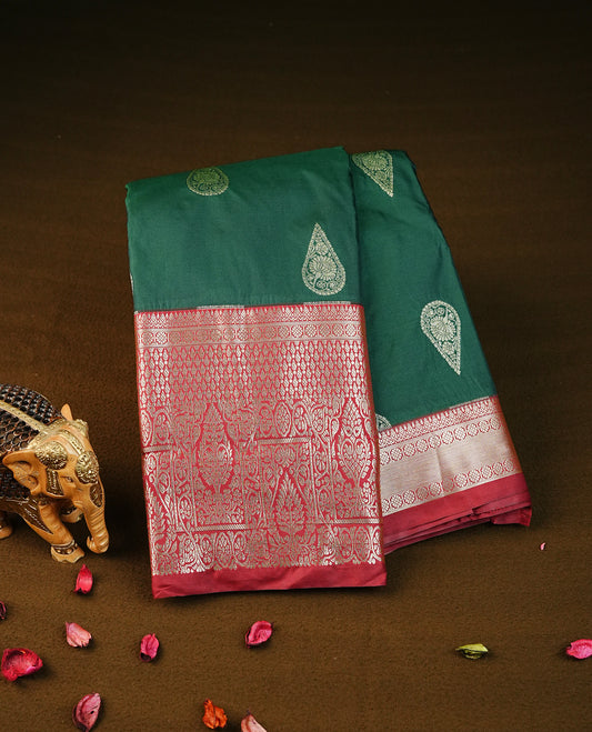 Bottle green colour semi wedding silk saree featuring light gold zari mango motifs on body, contrast maroon traditional border on body, rich pallu comes with matching blouse piece