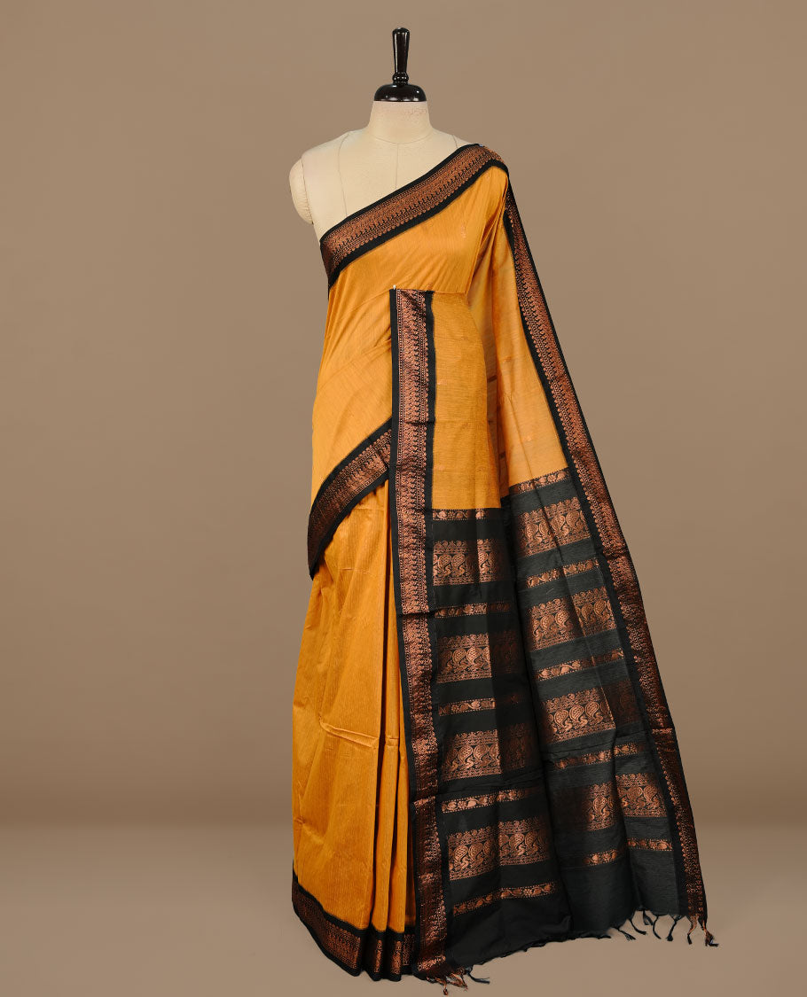 Mustard colour kalyani cotton saree featuring Elegant plain body, complemented by Black colour with Antique zari border, paired with matching blouse piece.