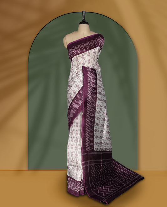 Classic off white colour saree adorned with intricate grape colour tribal motifs and rich woven patterns on the pallu and border & Paired with matching blouse.