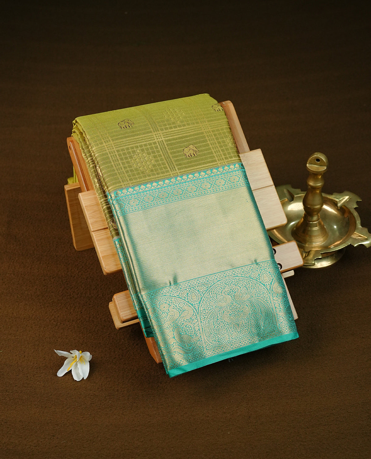 Pista colour semi wedding saree featuring gold zari check with elephant motifs on body complemented by contrast aqua green colour with traditional border, comes with macthing blouse piece.