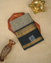 Grey colour chettinad cotton saree Featuring Gold zari check pattern on body, complemented by contrast black colour with zari border, comes with matching blouse piece.