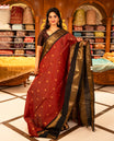 Maroon with Black colour Chettinad cotton saree featuring Gold zari strips with peacock motifs on body, complemented by contrast colour border with zari design & grand pallu, comes with matching blouse piece.