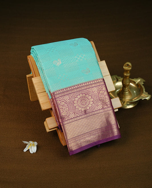 Aqua green colour semi wedding saree featuring gold zari check with motifs on body complemented by contrast purple colour with traditional border, comes with macthing blouse piece.