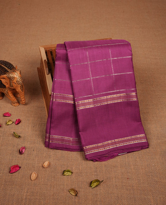 Twilight Magenta colour pure traditional Kancheepuram silk saree adorned with an elegant zari check pattern across the body, complemented by a simple zari woven border, paired with a matching blouse piece.