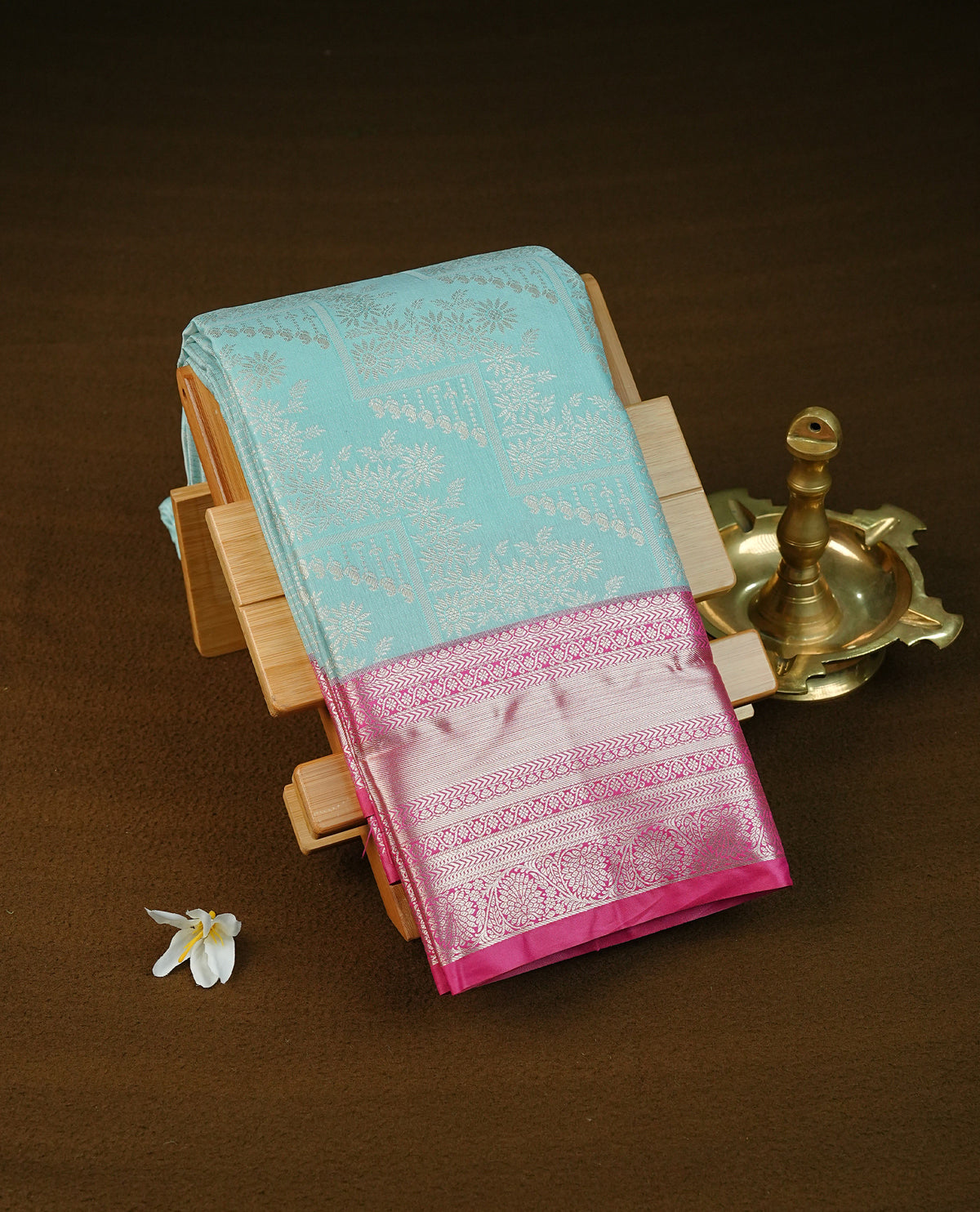 Ice blue colour  semi wedding saree featuring gold zari check pattern with motifs across the body, complemented by a contrast magenta traditional border. Comes with a matching blouse piece.