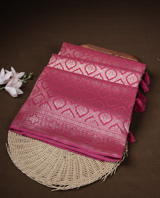 Rani pink colour banaras satin crepe saree featuring gold zari pattern across body, with self colour border with gold zari pattern and paired with matching blouse.