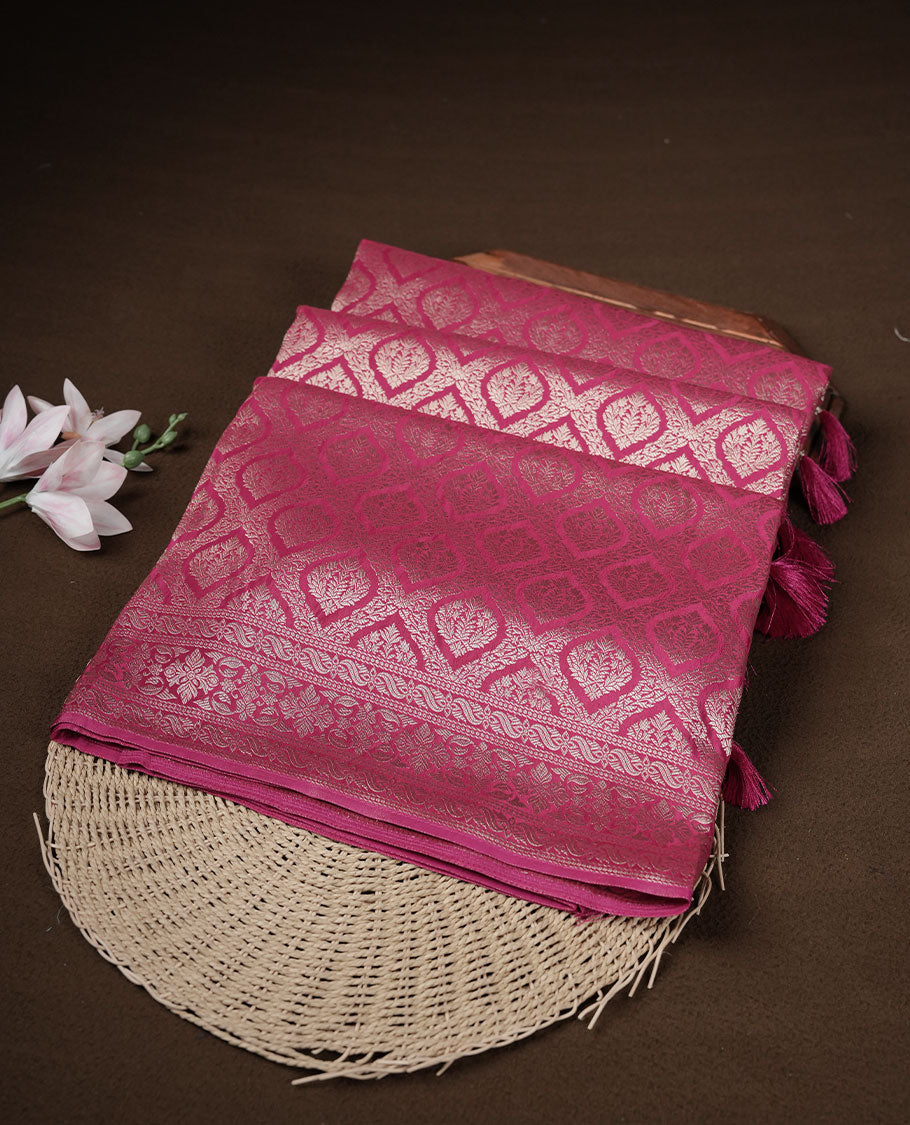Rani pink colour banaras satin crepe saree featuring gold zari pattern across body, with self colour border with gold zari pattern and paired with matching blouse.