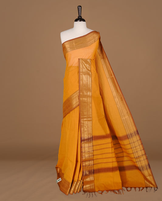 Mustard colour Chettinad cotton saree featuring Elegant plain body, complemented by contrast Light Brown colour with gold zari border, paired with matching blouse piece.