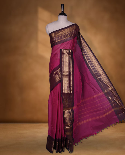 Magenta colour chettinad cotton saree featuring plain body, contrast brown colour with traditional gold zari border paired with matching blouse.