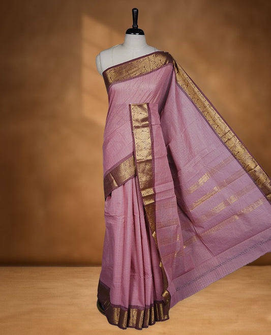 Light pink colour sungudi cotton saree featuring gold zari check pattern across body, contrast Mauve colour with gold zari peacock and floral pattern on border, without blouse piece.