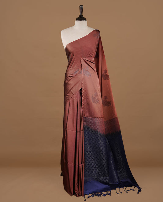 Brown colour soft silk saree features a sleek borderless design with intricate antique zari motifs, flowing into a striking contrast blue pallu and a matching blouse piece.