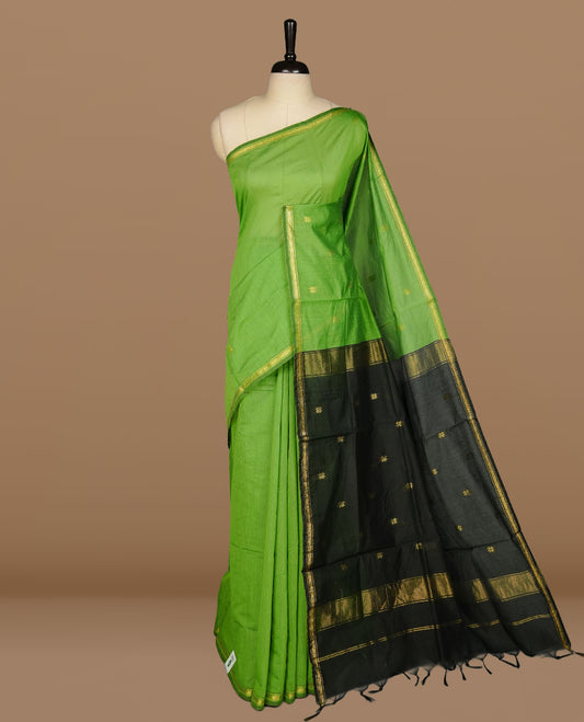 Green colour Maheshwari cotton saree features elegant gold zari motifs across the body, a classic gold zari border, a striking contrast pallu, and a matching blouse piece.